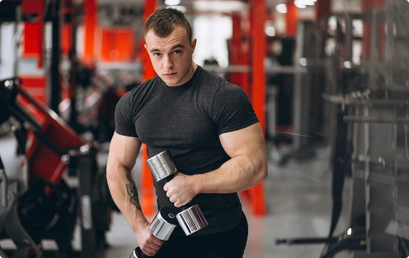 A man is lifting a dumbbell while exercising in a gym setting.